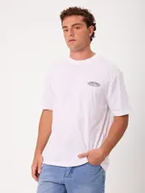 Remera blanca de manga corta y corte holgado de la marca Rusty, con estampado gráfico en la espalda con el logo de la marca en tonos grises.
