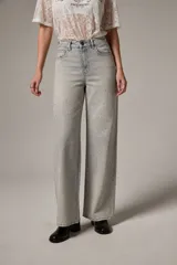 Pantalón jean de tiro alto y corte recto, confeccionado en denim celeste con aplicación de strass en toda la parte frontal.