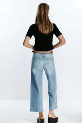 Jeans culotte de tiro alto color celeste, con corte wide leg y largo cropped. Incluye cinturón marrón de cuero.