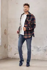 Sobrecamisa de corte holgado con diseño a cuadros en tonos azul marino y marrón, confeccionada con forro interior de corderito sintético, cuello clásico, cierre frontal de botones y bolsillos en el pecho.