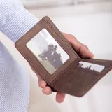 Billetera color beige de símil cuero lisa con galón elastizado marrón con línea blanca. Interior con doble repartición para billetes, visor y tarjeteros.