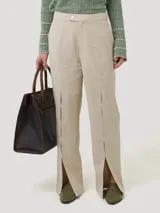 Pantalón de tiro medio color beige, confeccionado en mezcla de lino y viscosa. Presenta un corte recto con aberturas laterales en el bajo y cierre frontal con botón.