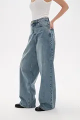 Pantalon de jean azul de corte ancho y tiro medio, con diseño de cinco bolsillos y cierre frontal con botón y cremallera.
