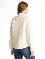 Campera combinada Current Air, con torso acolchado en diseño de rombos y mangas de tejido de punto grueso con diseño de ochos. Presenta cierre frontal metálico, cuello alto y puños y ruedo acanalados.