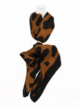 Pañuelo de seda con estampado geométrico en blanco, negro y gris, que incluye un anillo metálico dorado para sujetarlo.