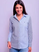Camisa entallada de manga larga con estampado de rayas verticales en tonos azul y celeste. Presenta cuello clásico, cierre frontal con botones y logo bordado en el pecho.