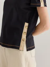 Remera color crema de algodón y lino, con cuello en V y mangas cortas abullonadas. Presenta cartera decorativa de botones en cuerpo y mangas.