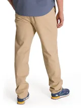 Pantalón chino Caterpillar de corte tapered straight, color beige, con tiro medio, bragueta con cremallera y botón, bolsillos laterales y bolsillos traseros con solapa y botón.