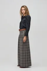 Camisa negra de algodón con cuello clásico, mangas largas con puños y hombros fruncidos que aportan volumen.