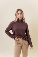 Polera de manga larga en color crudo, confeccionada en tejido suave y liviano con leve elasticidad. Presenta un cuello alto tipo tortuga y un calce regular, ideal para usar como prenda base o sola.