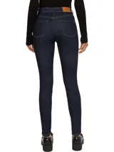 Pantalón de jean azul oscuro, corte skinny, con cinco bolsillos, cierre de botón y cremallera, parche de cuero con logo de Tommy Hilfiger en la cintura y logo bordado en el bolsillo trasero.