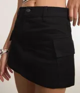 Pollera corta de sarga color negro, con diseño de tiro alto, cierre frontal con botón y cremallera, y bolsillos cargo laterales.
