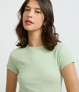 Blusa básica de manga corta y cuello redondo, confeccionada en malla rib de algodón con ajuste ceñido al cuerpo.