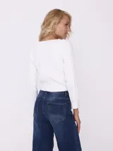 Sweater blanco de tejido de punto con trenzas y detalle torzado en el frente.