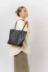 Cartera tipo tote de diseño estructurado y amplio, confeccionada en material sintético con textura graneada. Cuenta con doble asa larga para llevar al hombro y un compartimento principal espacioso.