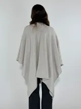 Ruana marrón con detalle de trenza frontal y terminación con flecos.