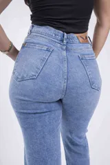 Pantalón de jean celeste con roturas en las rodillas y ruedo doblado.