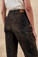 Pantalón de jean recto con estampado animal print en tonos marrones y negros.