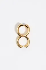 Anillo modular triple de metal dorado, compuesto por tres bandas unidas que presentan un diseño de corazones con esmalte negro en los extremos.