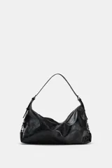 Bolso tipo saca color negro, de diseño flexible y acabado con efecto gastado. Cuenta con un asa ajustable para el hombro, detalles de hebillas y herrajes metálicos laterales, además de un cierre superior de cremallera metálica.