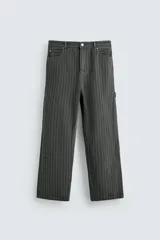 Pantalón de corte ancho (baggy fit) color verde oscuro/gris oscuro con finas rayas verticales blancas. Presenta cintura ajustable con trabillas laterales, bolsillos delanteros, bolsillos traseros de plastrón, bolsillo cerillero y una tira multifunción en la pernera.