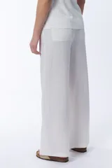 Pantalón blanco de lino, de corte recto y holgado, con cintura elastizada.