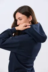Campera deportiva azul marino con capucha y cierre frontal, confeccionada en algodón con felpa. Presenta cordones ajustables al tono y puños ribeteados.
