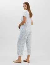 Conjunto de pijama de tres piezas en color celeste con estampado floral blanco y detalles de puntilla de encaje. Incluye una musculosa de breteles finos con escote en V, un capri con cintura elástica y cordón ajustable, y una camisa a juego.