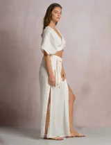 Pantalón palazzo de lino color azul, de tiro alto con cintura elastizada y cinto lazo incorporado con cuentas decorativas en las puntas. Presenta aberturas laterales pronunciadas en las piernas y corte amplio.