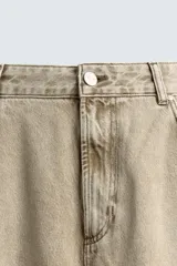 Jeans de corte holgado y amplio en toda la pierna, tiro medio. Tejido rígido con estampado a cuadros con efecto lavado. Cuenta con cinco bolsillos y cierre frontal con cremallera y botón.