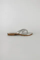 Sandalias plateadas tipo chancletas con suela de goma flexible y doble tira de cuero metalizado en la capellada.