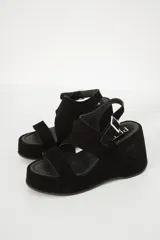 Sandalias de plataforma color marrón oscuro, con dos tiras anchas sobre el empeine y tobillo con hebilla.