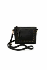 Cartera de formato compacto confeccionada en cuero sintético negro con textura, detalle de tachas metálicas doradas en el frente, bolsillo frontal con cierre y correa larga regulable y desmontable.