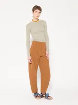 Remera de punto con textura suave, manga larga y escote redondo. Presenta un diseño ajustado al cuerpo con espalda abierta y largo a la primera cadera.