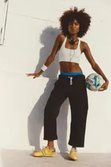 Pantalón deportivo negro de tejido de punto, corte holgado con piernas ligeramente ajustadas hacia el tobillo y costuras definidas.