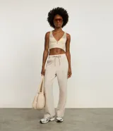 Pantalón deportivo de corte recto confeccionado en microfibra color beige. Presenta cintura elástica con lazo ajustable y bolsillos laterales.