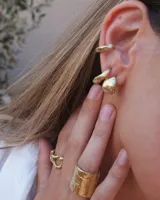 Earcuff de metal plateado, diseño orgánico y texturizado, que se ajusta al cartílago de la oreja sin necesidad de perforación.