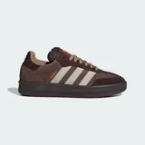 Championes Adidas modelo Samba XLG, de diseño urbano con suela de plataforma. Presentan una combinación de tonos marrones en gamuza y cuero, con las icónicas tres franjas laterales en color beige y detalles en naranja vibrante en la lengüeta y el lateral.