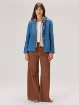 Pantalon de corte ancho y holgado, confeccionado en mezcla de algodón, viscosa y lino. Presenta costuras decorativas, pinzas debajo de la rodilla, bordado de monograma en el bolsillo delantero y pespuntes a contratono.