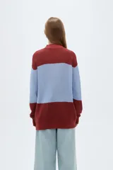 Sweater de punto holgado con cuello alto, diseño multicolor de bloques en tonos bordó, celeste y rojo, de manga larga.