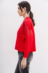 Sweater rojo de tejido de punto con cuello redondo y mangas largas. Diseño con lentejuelas rojas bordadas en el frente y las mangas.