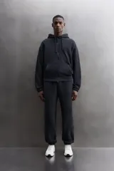 Sudadera con capucha y cierre de cremallera de doble dirección, color negro, de corte relaxed fit, con bolsillos frontales tipo canguro y puños y bajo elásticos.