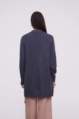 Saco abierto de punto, color gris claro, con diseño holgado y mangas largas.