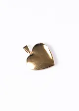 Dije relicario dorado con forma de corazón y diseño floral.