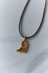 Dije de acero quirúrgico con forma de bota de estilo cowboy, con detalles grabados en relieve.
