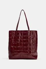Bolso shopper de cuero bordó con estampado texturizado símil cocodrilo, diseño estructurado y doble asa fina para hombro.