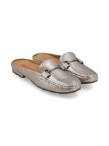 Mocasín tipo mule destalonado de cuero metalizado color peltre, con detalle de hebilla metálica ornamental en el empeine y suela de goma.