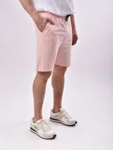 Bermuda de algodón color crudo, de corte recto y largo a la rodilla, con cintura elástica y cordón ajustable negro.