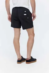 Short de baño azul, de corte clásico y largo corto, con cintura elástica y cordón ajustable bicolor. Cuenta con bolsillos laterales y uno trasero.