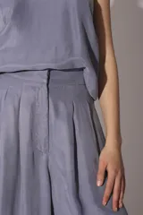 Pantalón palazzo de tiro alto color gris, con pinzas delanteras y bolsillos laterales.